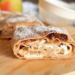 Close-up of a freshly baked apple cinnamon roll with powdered sugar.
