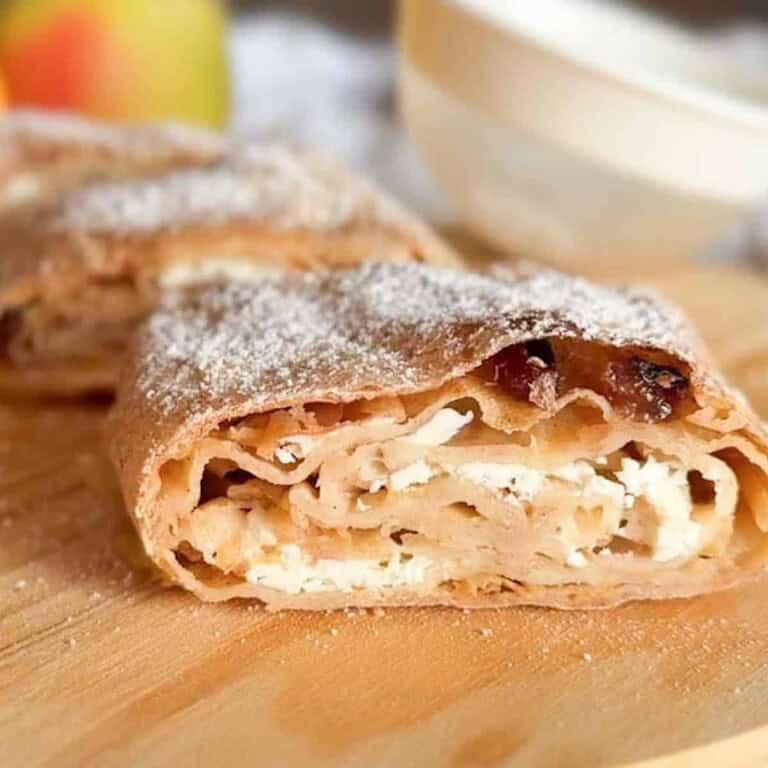Close-up of a freshly baked apple cinnamon roll with powdered sugar.