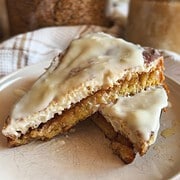 Close-up of cinnamon roll sourdough French toast with icing.