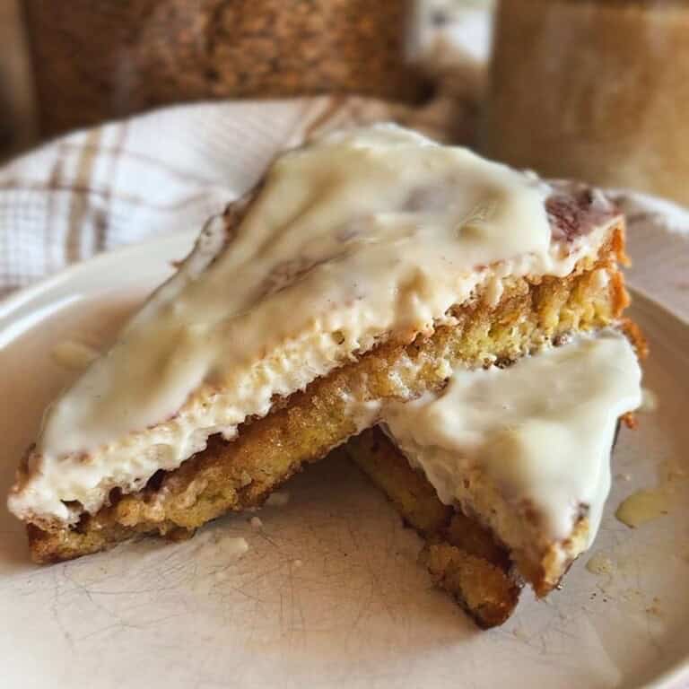 Close-up of cinnamon roll sourdough French toast with icing.