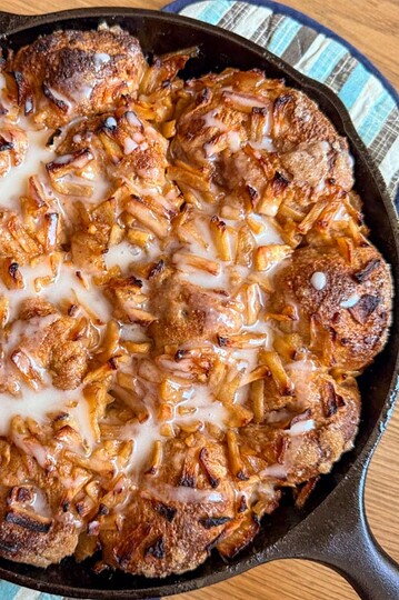 Delicious apple pie pull-apart baked in a skillet with caramelized apples and melted cheese.