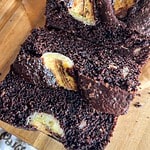 Close-up of moist chocolate banana bread with banana slices on top.
