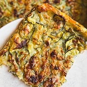 Close-up of vegetable frittata with zucchini and melted cheese.