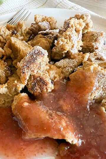 Crispy fried chicken served with fruit-based sauce on a white plate.