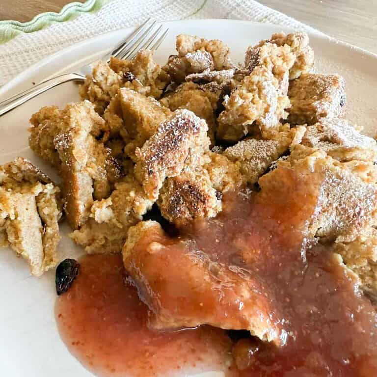Crispy fried chicken served with fruit-based sauce on a white plate.