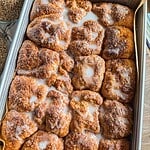 Close-up of freshly baked cinnamon rolls with icing glaze.