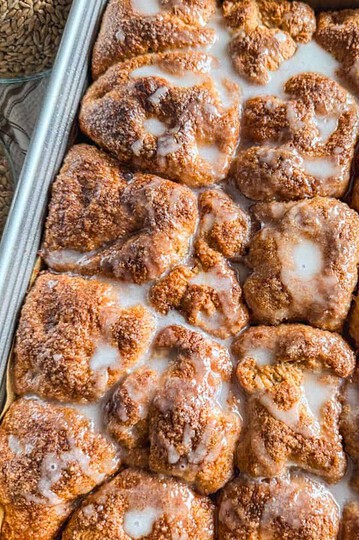 Close-up of freshly baked cinnamon rolls with icing glaze.