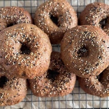 Close-up of freshly baked bagels with seeds on top.