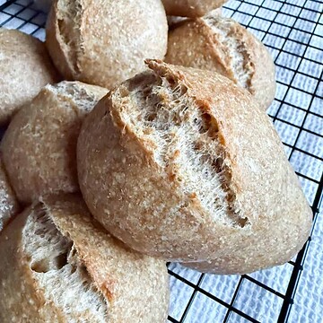 Close-up of freshly baked bread rolls on a cooling rack.