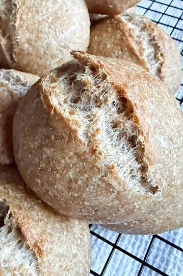 Close-up of freshly baked bread rolls on a cooling rack.