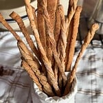Crispy breadsticks in a white cup for baking.