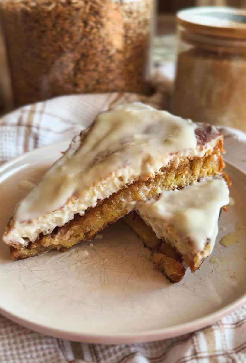 Close-up of a homemade cake with white icing and a slice cut out.