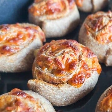 Close-up of baked stuffed pizza breads with melted cheese and toppings.