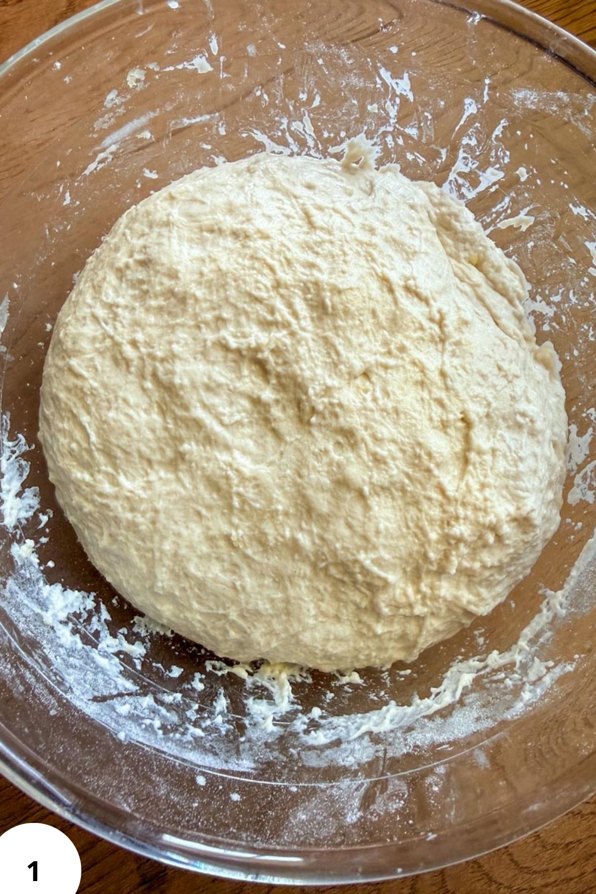 Fresh sourdough bread dough in a glass bowl for focaccia baking.