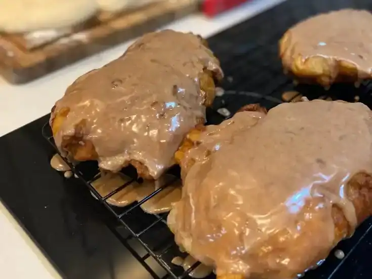 Chicken fried steaks with gravy cooling on a wire rack.