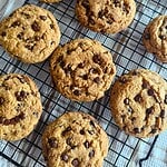 Freshly baked chocolate chip cookies cooling on a wire rack.