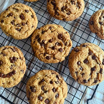 Freshly baked chocolate chip cookies cooling on a wire rack.