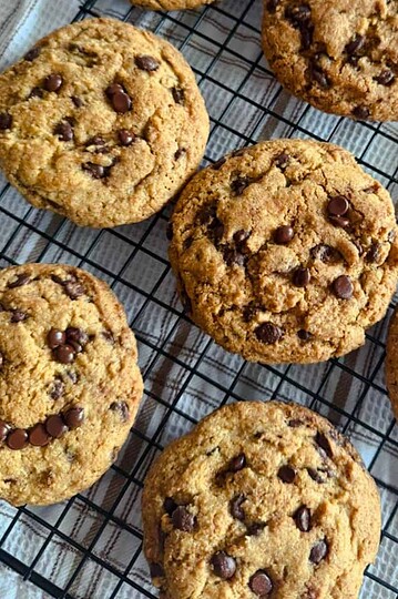 Freshly baked chocolate chip cookies cooling on a wire rack.