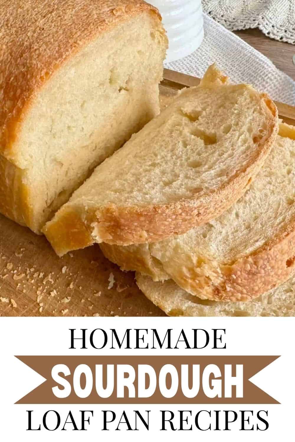 Freshly baked homemade sourdough bread with slices on a wooden surface.