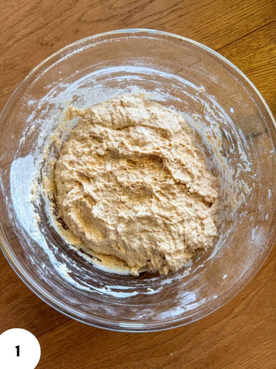 Dough in a glass bowl ready for kneading and folding.