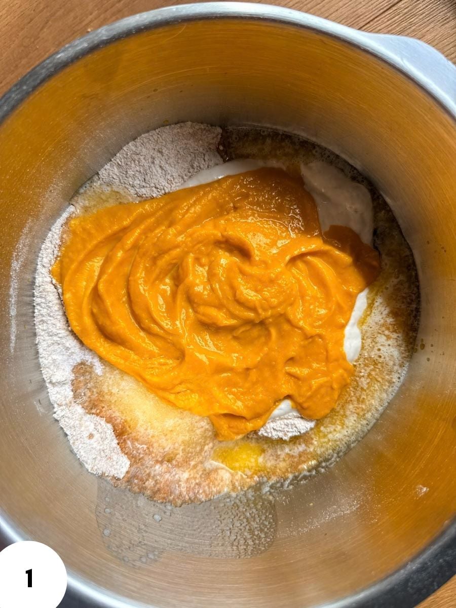 Dough with pumpkin puree in a mixing bowl for bread baking.