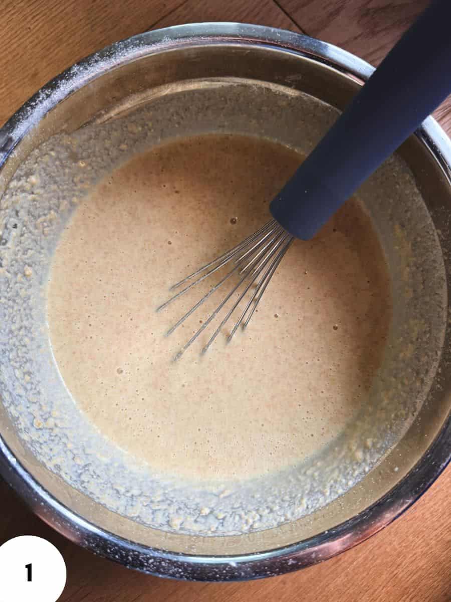 Bowl of bread dough being mixed with a whisk for stretch and folds.