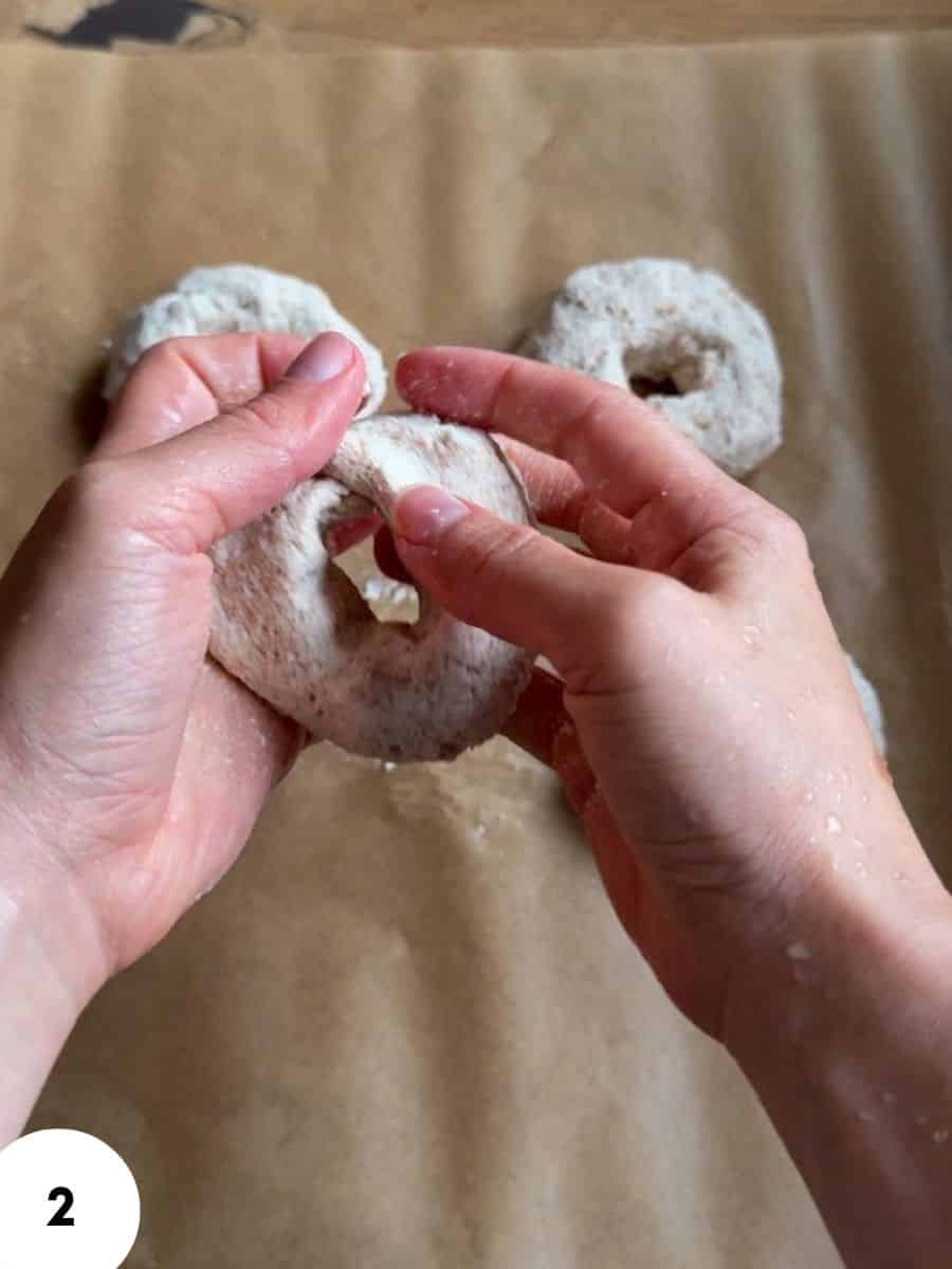 Hands performing stretch and fold technique on bread dough for baking.