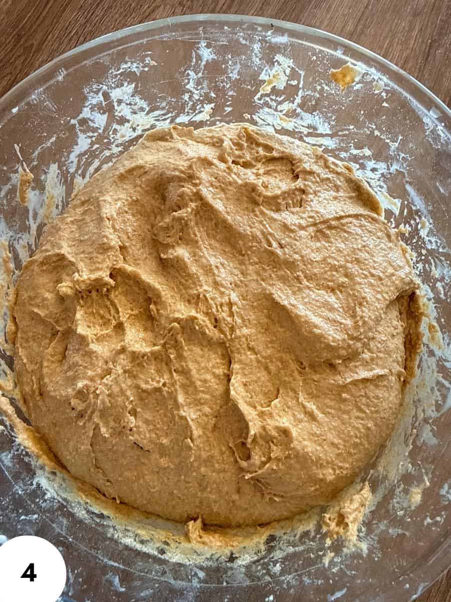 Fermented bread dough in a glass bowl for baking or proofing.