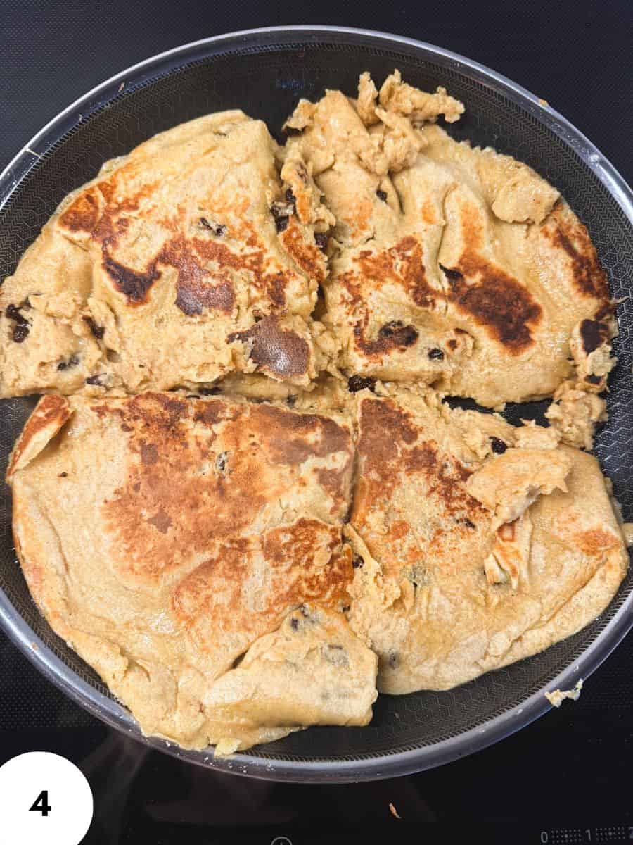 Dough undergoing stretch and fold technique in a black pan.