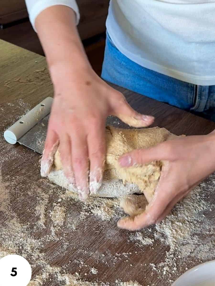 Person performing stretch and fold dough technique for bread making.