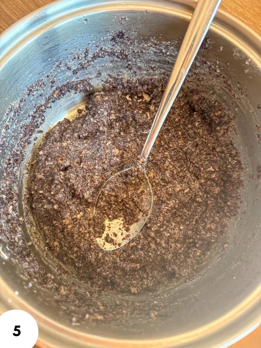 Close-up of dough in a mixing bowl with a metal spoon for stretch and folds.
