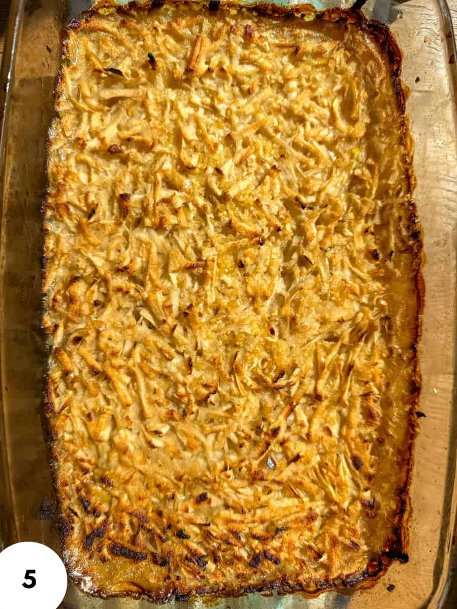 Baked chicken casserole with cheese and crispy edges in a glass dish.