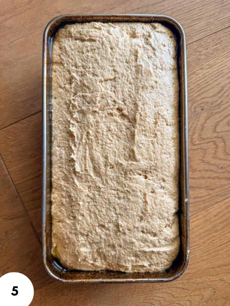 Unbaked bread dough in a metal pan ready for proofing or baking.