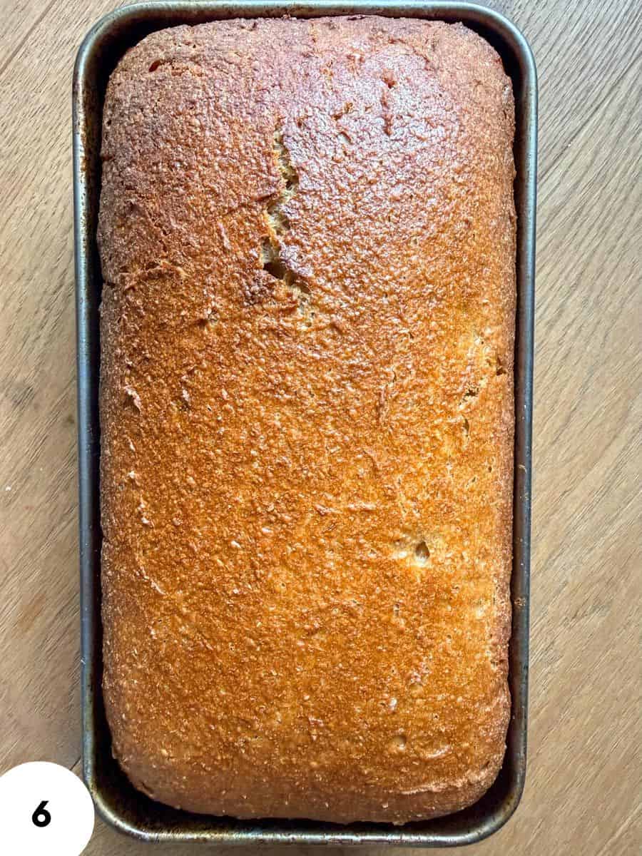 Golden brown bread loaf in a baking pan, perfect for slicing and serving.