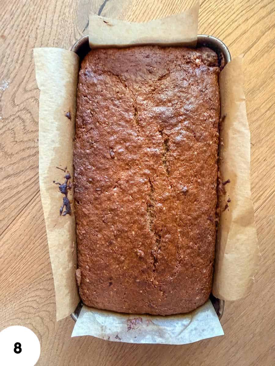 Freshly baked einkorn banana bread in a baking pan with parchment paper.