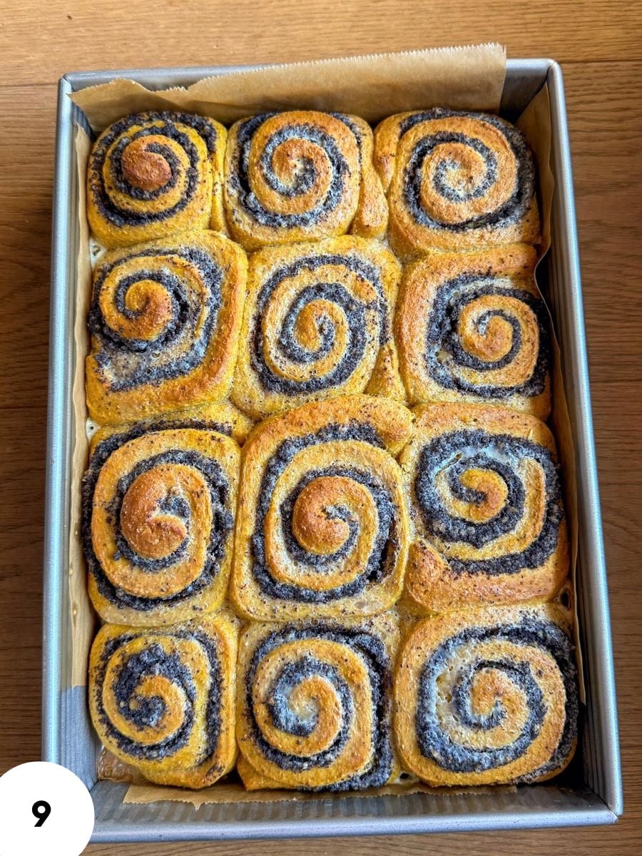 Freshly baked cinnamon rolls with purple filling in a baking tray.