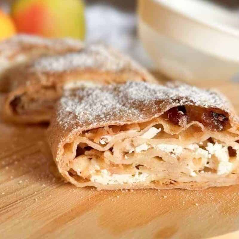 Delicious apple strudel with flaky crust and dusting of powdered sugar.