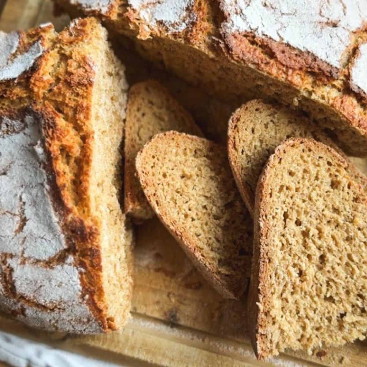 Close-up of sliced homemade sourdough bread on a wooden surface.