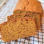 Freshly baked einkorn banana bread slice on cooling rack.