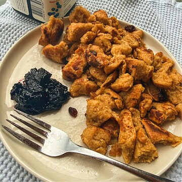 Close-up of homemade chicken and fruit fritters with a side of jam on a plate.