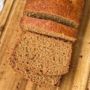 Freshly baked whole wheat bread sliced on a wooden board.