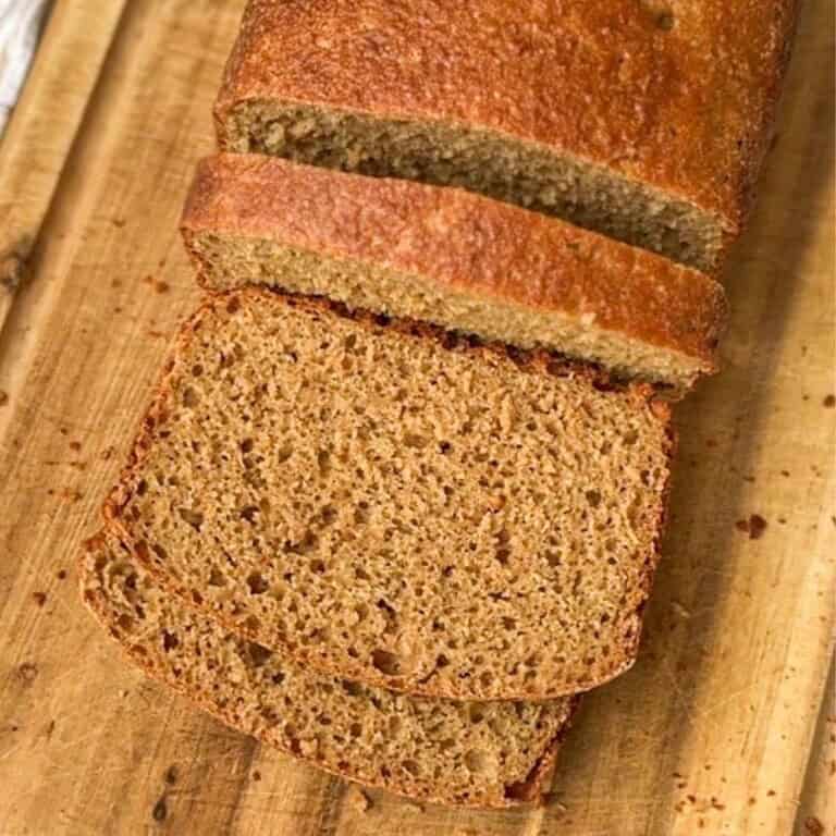 Freshly baked whole wheat bread sliced on a wooden board.
