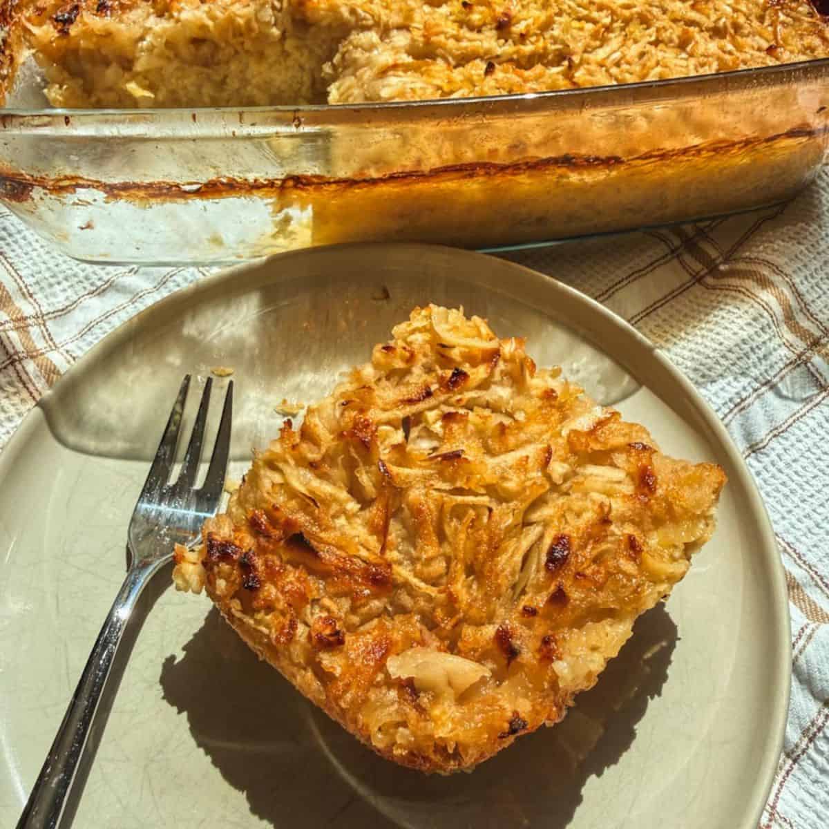 Close-up of a slice of apple crisp on a plate with a fork.