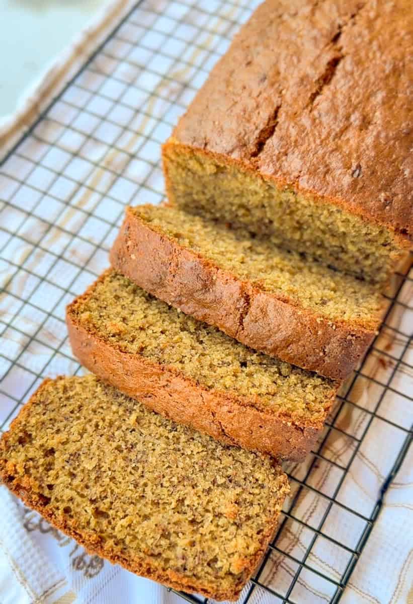 Freshly baked einkorn banana bread slices on a cooling rack.