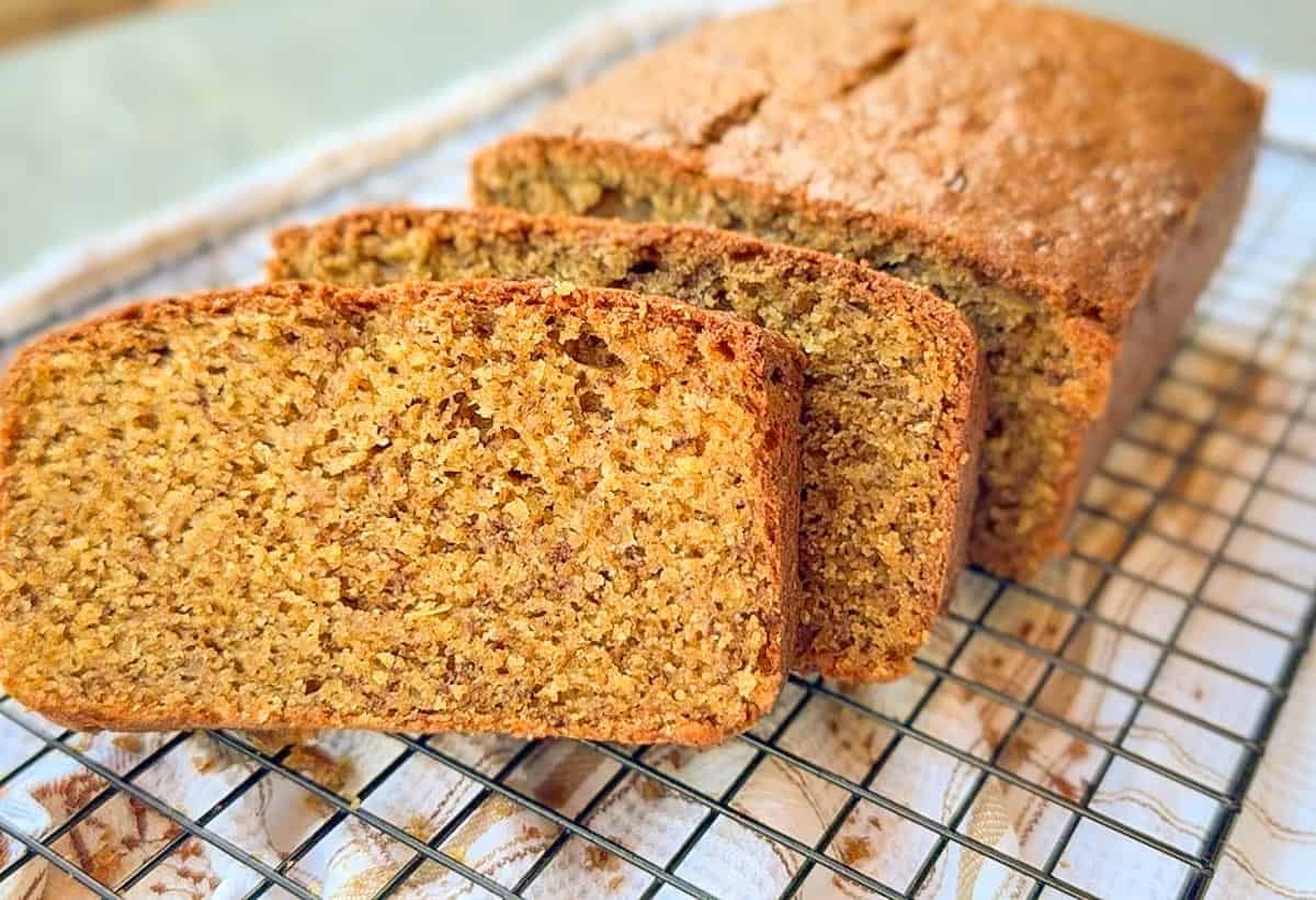 Homemade einkorn banana bread sliced on a cooling rack.