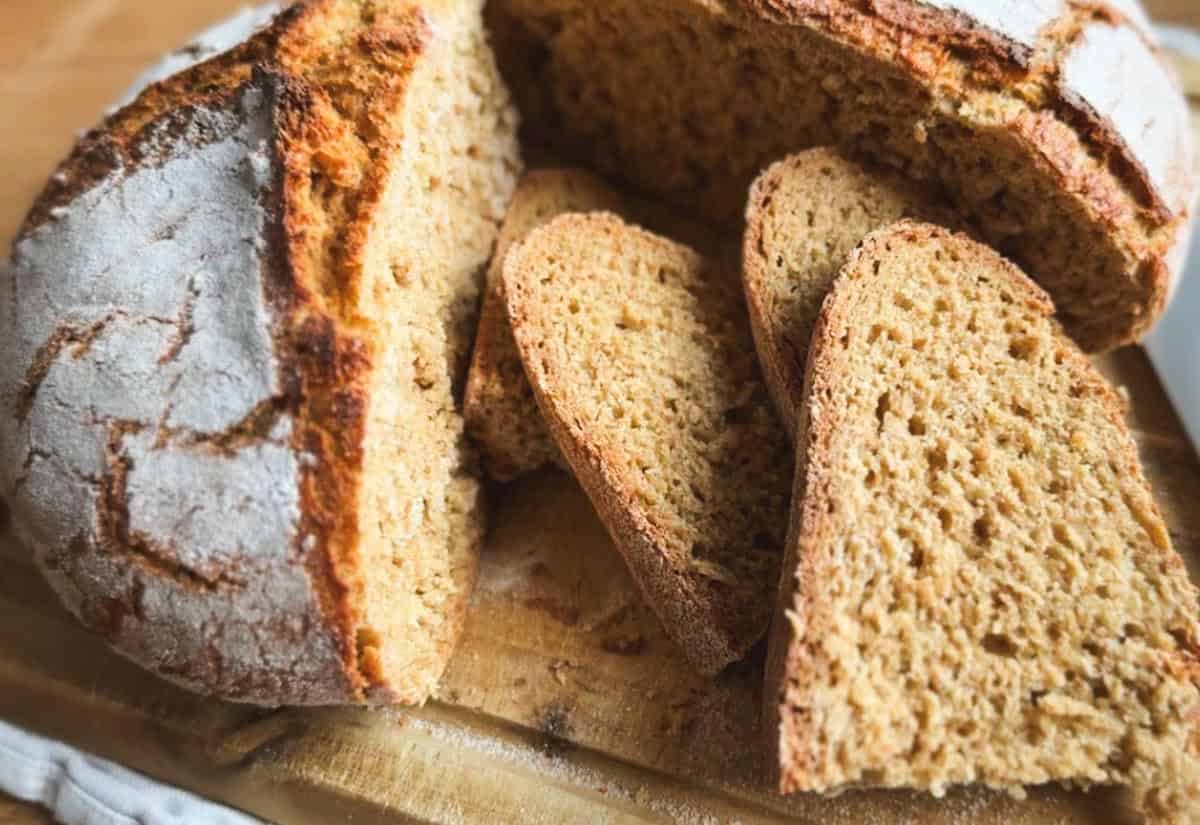 Freshly baked artisan bread sliced on a wooden board.