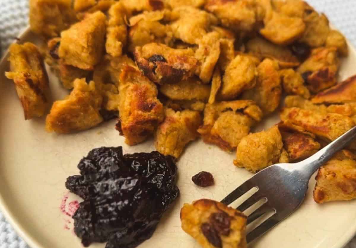 Close-up of fried chicken pieces with blackberry jam on a plate.