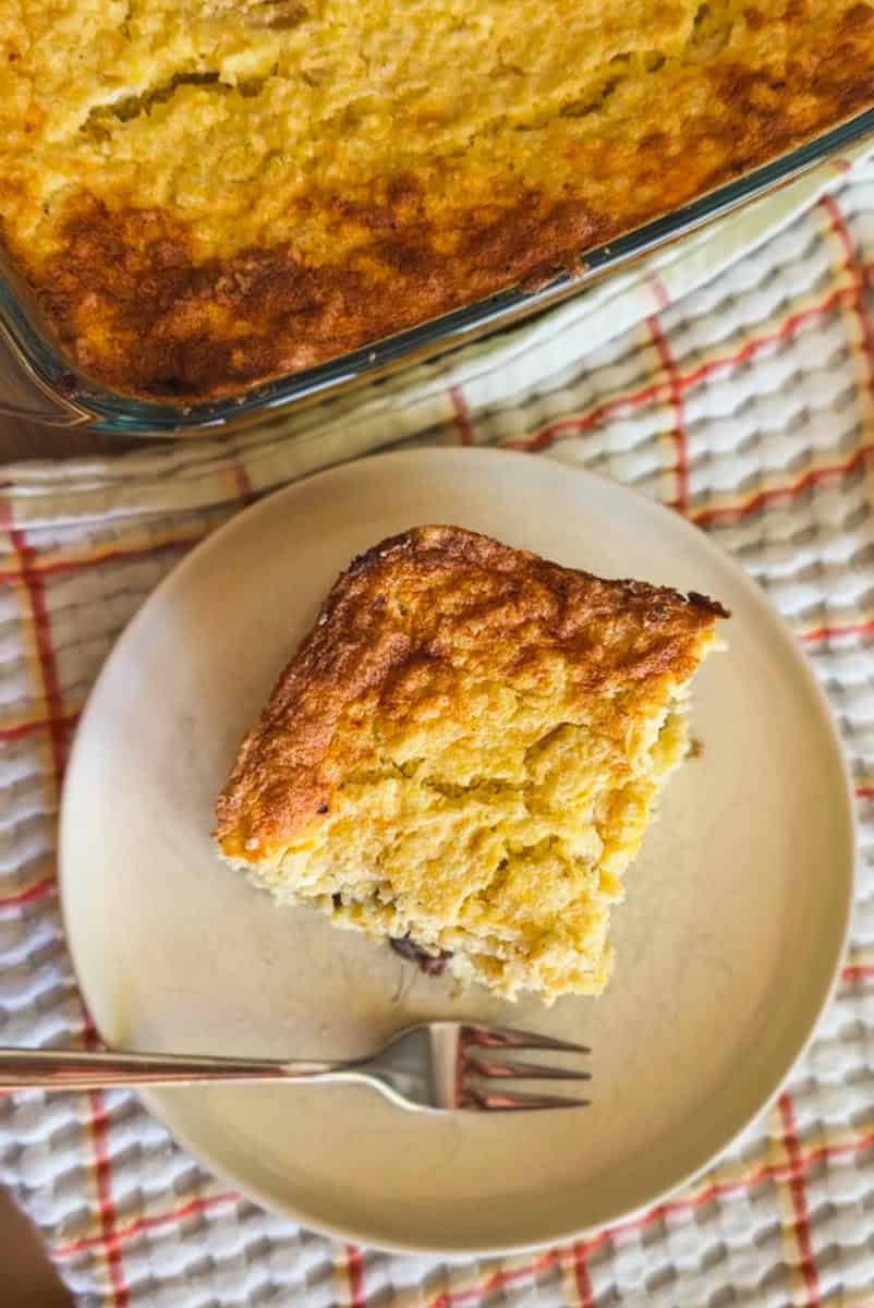 Slice of homemade lemon cake on a white plate with a fork.