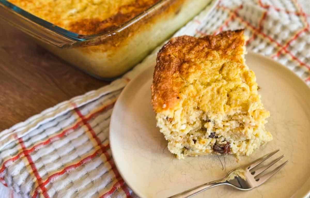 Close-up of a slice of homemade cornbread on a plate with a fork.