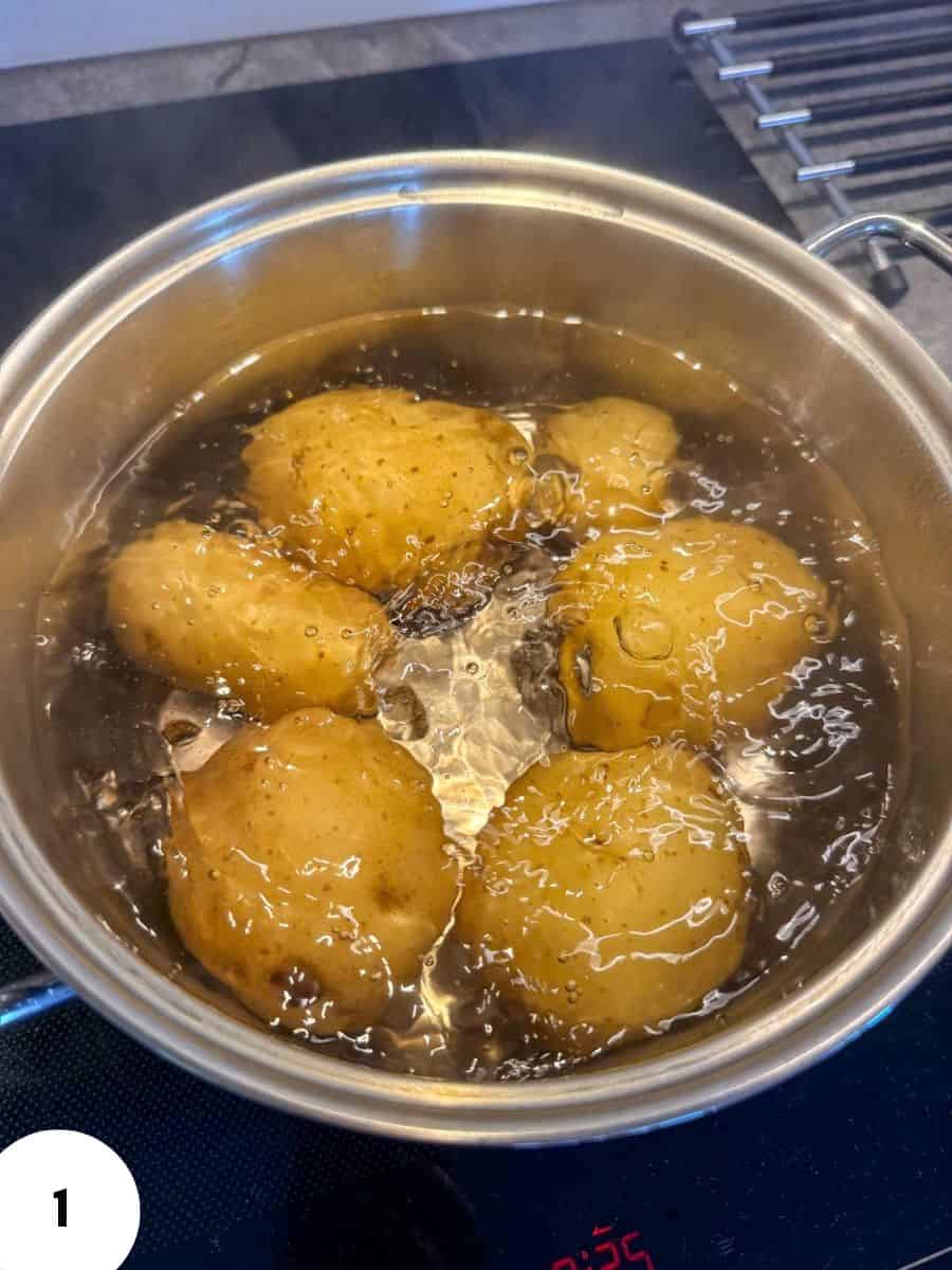 Potatoes boiling in a pot on the stove for baking or cooking.